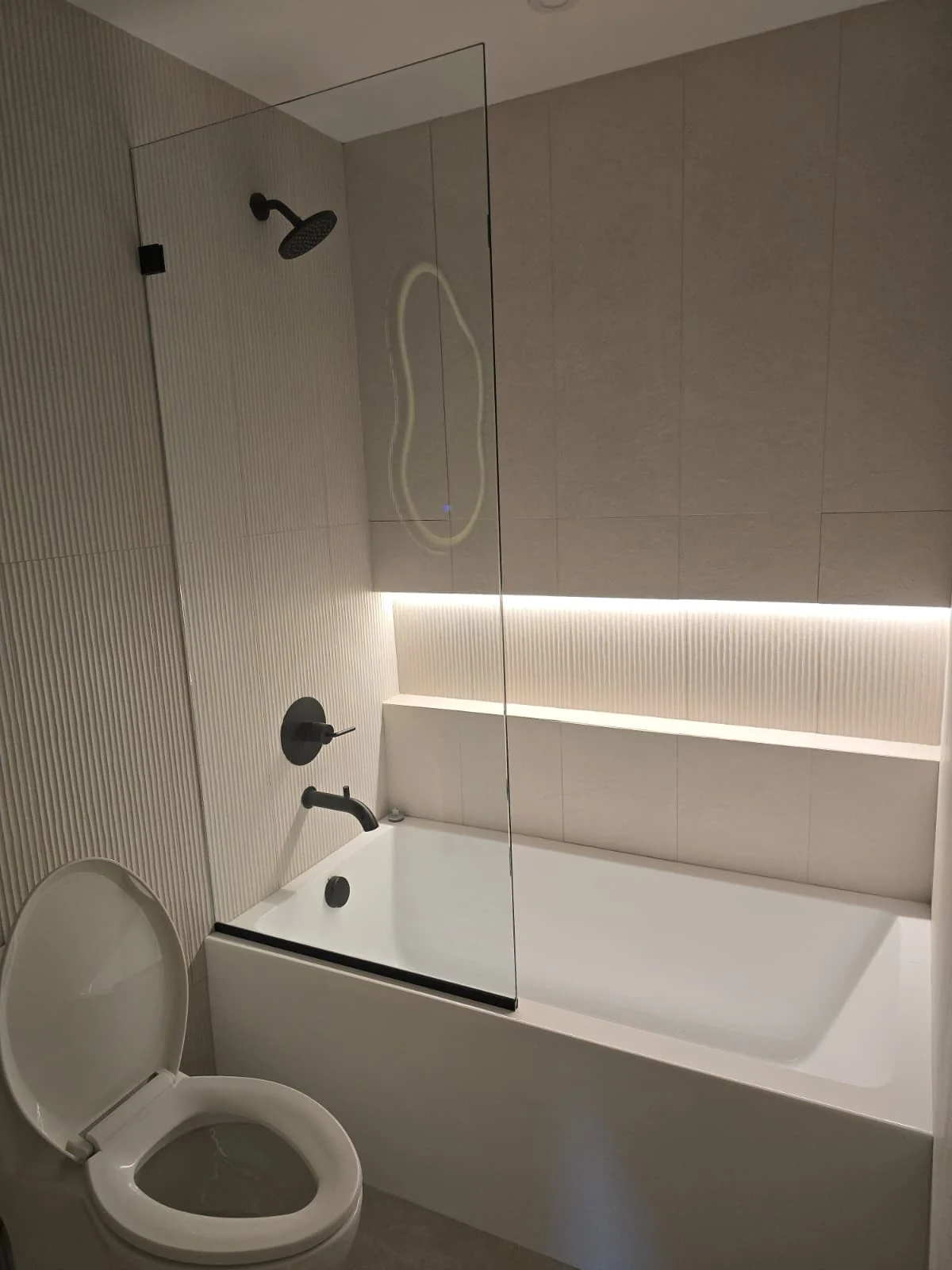 Bathroom with concealed linear accent lighting beside a tub