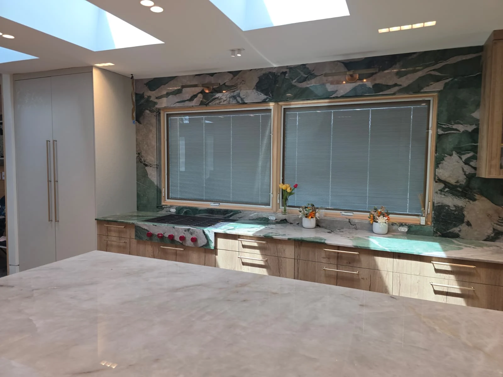Stone kitchen with skylights and layered task lighting