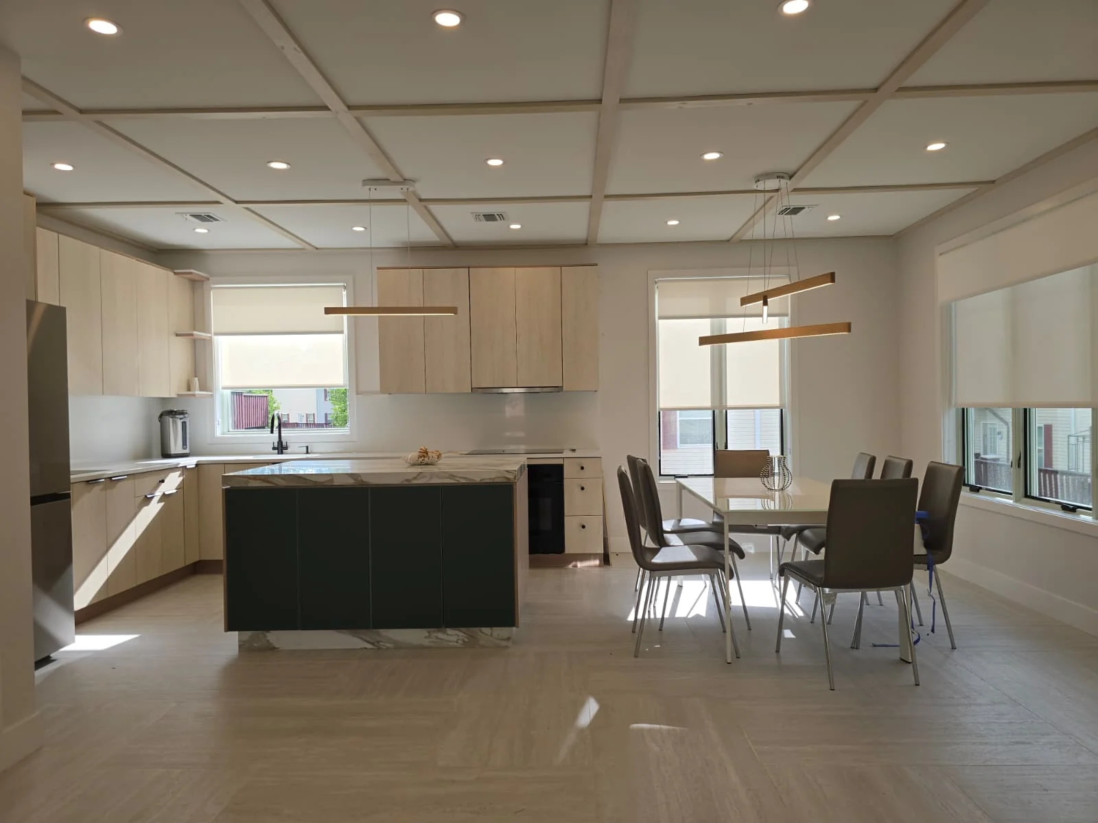 Modern kitchen with recessed lights and linear pendant fixtures