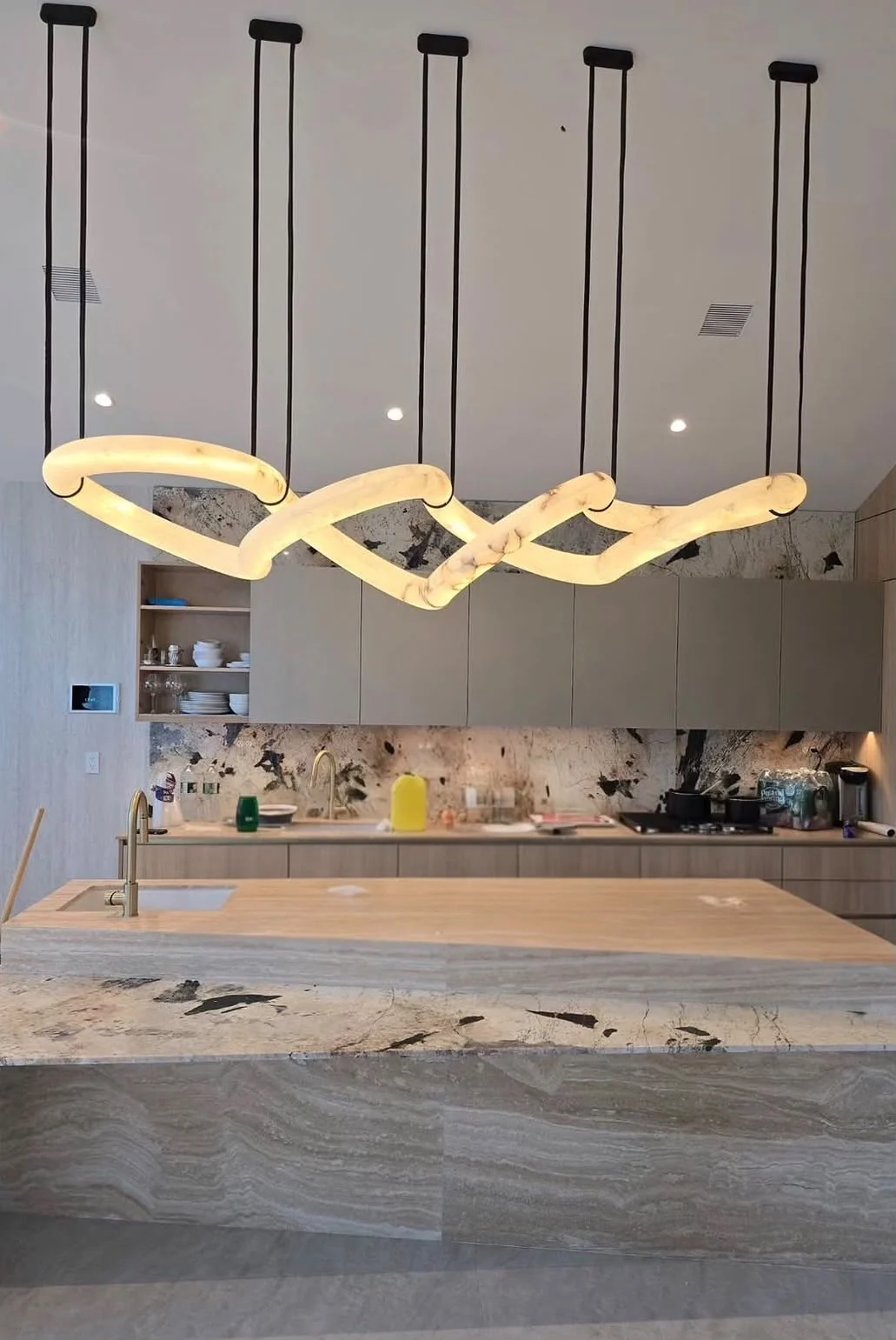 Statement pendant light installed over a modern kitchen island